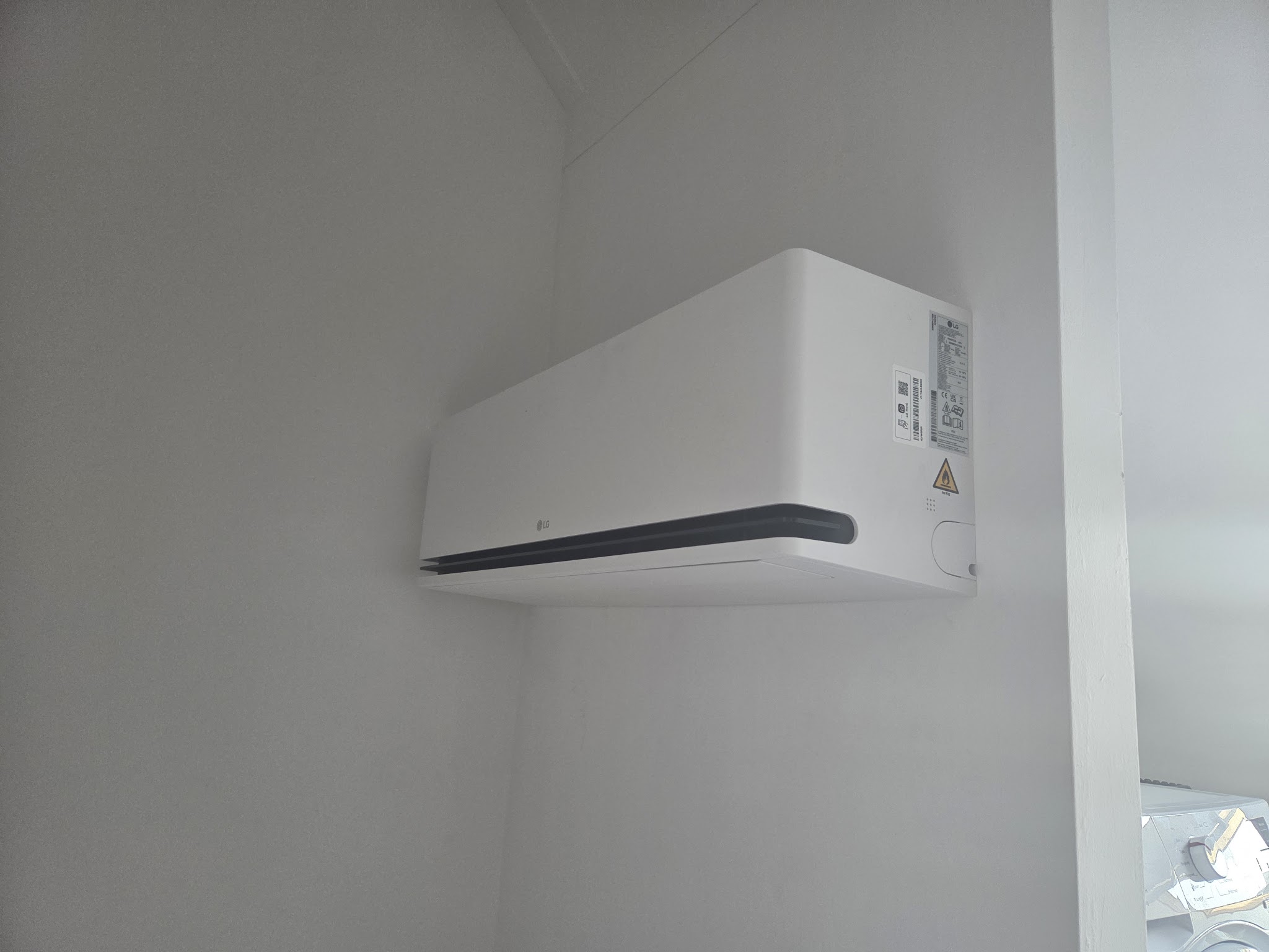 Witte binnenunit hoog aan een lichte wand