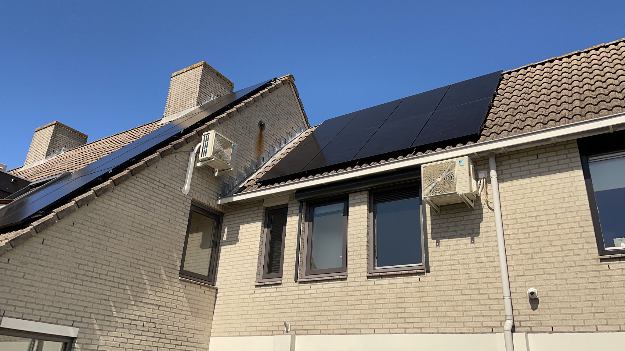 Woning met zonnepanelen en twee buitenunits aan de gevel